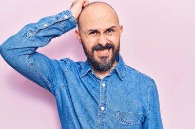 Gündelik kıyafetler giyen genç yakışıklı adam kafaları karıştırır ve soru sorar. Şüpheyle kararsız, kafa kafaya düşünerek. Düşünceli kavram. 