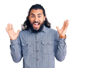 Genç Arap adam gündelik giysiler giyip çılgınlığı kutluyor ve başarıya hayret ediyor kolları açık ve gözleri açık heyecanla haykırıyor. Kazanan konsept 