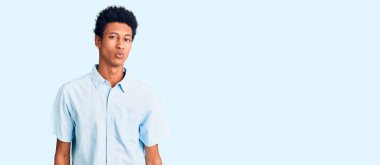 Genç Afro-Amerikalı sıradan kıyafetler giymiş kameraya bakıp havada öpücük yollayan sevimli ve seksi bir adam. aşk ifadesi. 