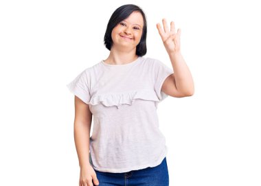 Down sendromlu esmer kadın günlük beyaz tişört giyer ve parmaklarını dört numaralı parmaklarıyla göstererek gülümser ve mutlu olur.. 