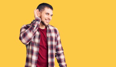 Gündelik tişört giyen genç yakışıklı adam kulağına fısıldayarak dedikoduları ve dedikoduları dinliyor. Sağırlık kavramı. 