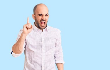 Zarif gömlek giyen genç yakışıklı adam başarılı bir fikirle işaret ediyor. Heyecanlı ve mutlu. Bir numara.. 