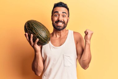 Karpuz tutan genç İspanyol adam gururla bağırıyor, zaferi kutluyor ve başarıyı kollarını kaldırarak kutluyor. 