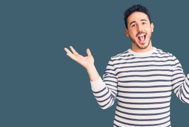 Sıradan kıyafetler giyen genç İspanyol adam çılgın ve başarıyı kollarını kaldırıp heyecanla haykırarak kutluyor. Kazanan konsept 