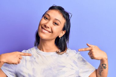 Gündelik kıyafetler giyen, kendine güveni olan, kendini gururlu ve mutlu gösteren genç bir kadın.. 