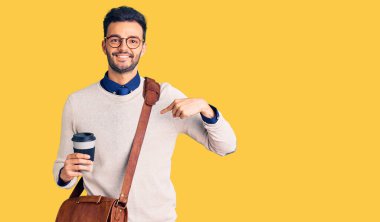 Deri çanta giyen ve kahve içen genç, yakışıklı İspanyol adam mutlu ve gururlu bir kişiyi işaret ediyor. 