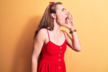 Yazlık elbise giyen, güneş gözlüğü takan, el ele tutuşup bağıran genç ve güzel bir sarışın kadın. iletişim konsepti. 