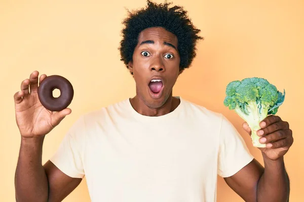 Fešák Africký Američan Afro Vlasy Drží Brokolici Čokoládové Koblihy Slaví — Stock fotografie