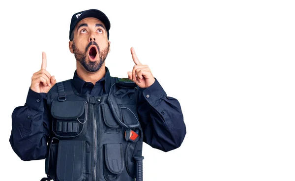 Joven Hispano Vistiendo Uniforme Policial Asombrado Sorprendido Mirando Hacia Arriba — Foto de Stock