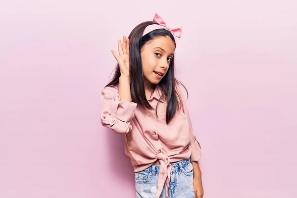 噂やゴシップに耳を傾け手で笑みを浮かべてカジュアルな服を着て美しい子供の女の子 聴覚障害の概念 — ストック写真
