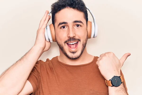 Fiatal Spanyol Férfi Zenét Hallgat Fülhallgatóval Hüvelykujjával Felfelé Mosolyogva Boldogan — Stock Fotó