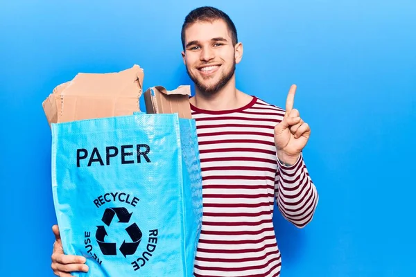 Jovem Homem Bonito Reciclando Papel Sorrindo Com Uma Ideia Pergunta — Fotografia de Stock