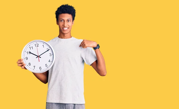 Young African American Man Holding Big Clock Pointing Finger One — Stock Photo, Image