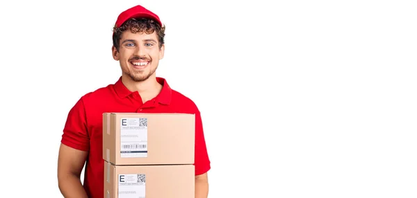 Jovem Homem Bonito Com Cabelo Encaracolado Segurando Pacote Entrega Olhando — Fotografia de Stock