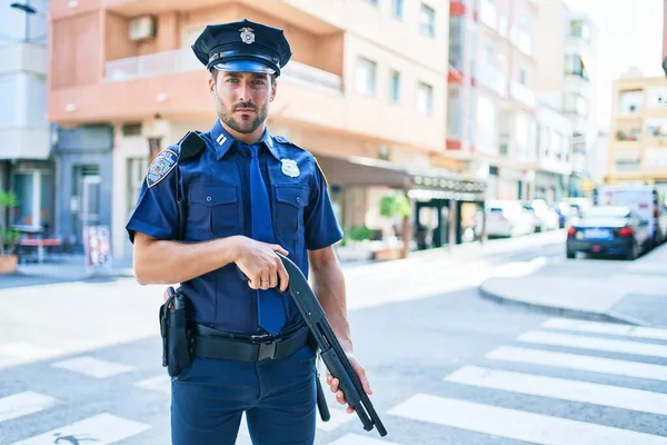 Młody Przystojny Policjant Mundurze Policyjnym Poważnym Wyrazem Twarzy Trzymający Strzelbę — Zdjęcie stockowe