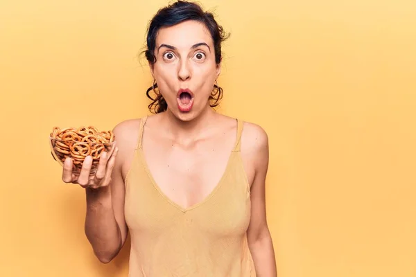 Young Beautiful Hispanic Woman Holding Pretzels Scared Amazed Open Mouth — Stock Photo, Image