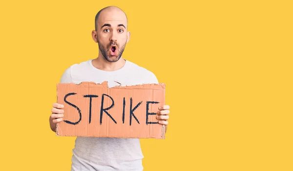 Young Handsome Man Holding Strike Banner Scared Amazed Open Mouth — Stock Photo, Image