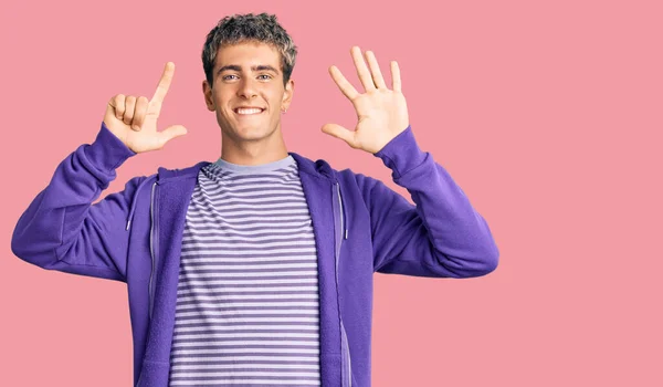 年轻英俊的男子穿着休闲的紫色运动衫 露出七号手指 面带微笑 自信而快乐 — 图库照片