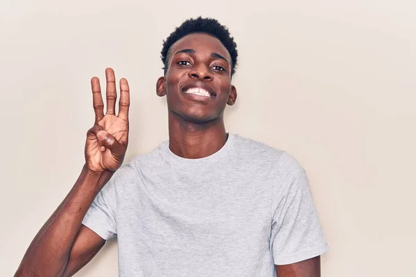 身穿休闲装的年轻的非洲裔美国人 带着自信和快乐的笑容 用手指指着三号 — 图库照片