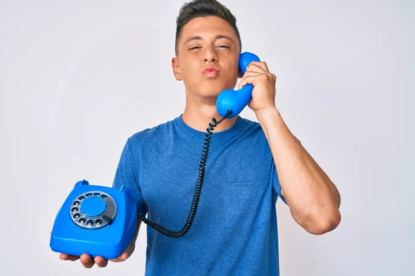 Menino Hispânico Jovem Segurando Telefone Vintage Olhando Para Câmera Soprando — Fotografia de Stock
