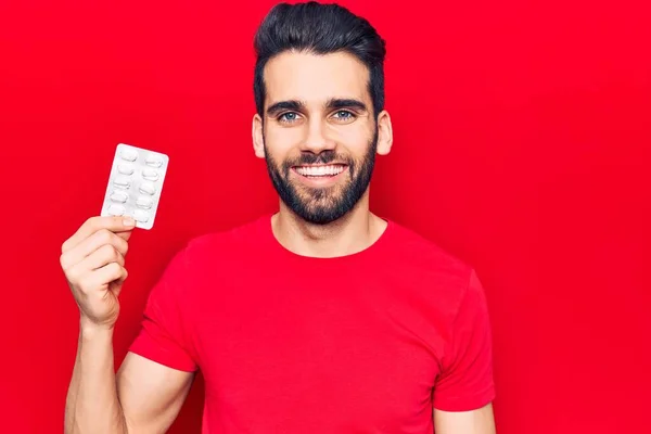 Joven Hombre Guapo Con Barba Sosteniendo Píldoras Que Parecen Positivas —  Fotos de Stock