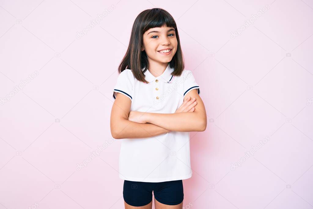 Young little girl with bang wearing sportswear happy face smiling with crossed arms looking at the camera. positive person. 