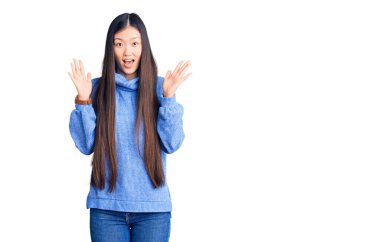 Balıkçı yaka kazak giyen genç ve güzel bir kadın çılgın bir kutlama yapıyor ve kolları havada ve gözleri açık heyecanla haykırarak başarıyı kutluyor. Kazanan konsept 