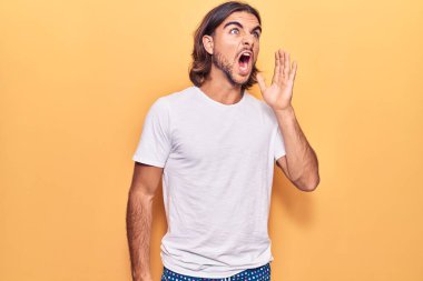 Sıradan kıyafetler giyen genç yakışıklı adam el ele verip bağırarak ve yüksek sesle bağırıyor. iletişim konsepti. 