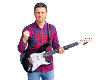 Elektro gitar çalan yakışıklı genç adam öfkeyle bağırıyor, öfkeyle bağırıyor ve el kaldırıyor. 