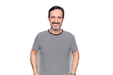 Orta yaşlı, çizgili tişört giyen yakışıklı bir adam izole edilmiş beyaz arka planda mutlu ve havalı bir gülümsemeyle dikiliyor. Şanslı kişi..