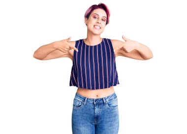 Pembe saçlı, sıradan kıyafetler giyen, kendine güvenen, gülümseyen, kendini gururlu ve mutlu gösteren genç ve güzel bir kadın.. 