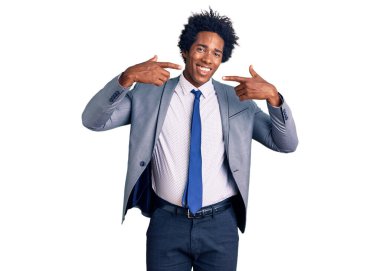 Afro saçlı, iş ceketi giyen, neşeli gülümseyen ve parmaklarıyla ve ağzıyla işaret eden yakışıklı Afro-Amerikan erkeği. diş sağlığı kavramı. 