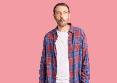 Gündelik kıyafetler giyen genç yakışıklı adam dudaklarıyla balık suratı yapıyor, çılgınca ve komik bir jest. Komik ifade. 