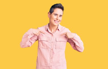 Kısa saçlı, günlük kıyafetler giyen, kendine güvenen, gülümseyen, kendini gururlu ve mutlu gösteren genç bir kadın.. 