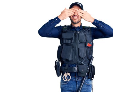 Polis üniforması giyen, elleri gülücüklü ve komik gözlerle bakan genç yakışıklı bir adam. kör kavram. 