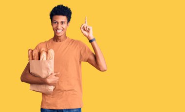 Afro-Amerikalı genç adam elinde ekmek torbası tutuyordu. Şaşırmış, şaşırmış ve parmaklarıyla işaret ediyordu. Kollarını kaldırmıştı.. 