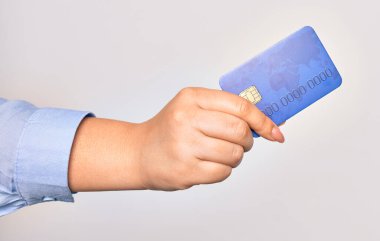 İzole edilmiş beyaz arka planda kredi kartı tutan beyaz bir kadının eli.