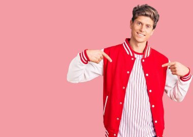 Beyzbol üniforması giyen yakışıklı bir genç. Kendine güvenen, yüzünde gülümseme olan, kendini gururlu ve mutlu gösteren bir adam.. 