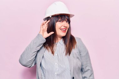 Mimar şapkası takan, ağzı kulaklarında gülümseyen dedikoduları ve dedikoduları dinleyen genç ve iri yarı bir kadın. Sağırlık kavramı. 