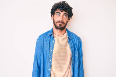 Kıvırcık saçlı ve ayılı, sıradan bir kot ceket giyen yakışıklı genç adam. Gülümsüyor, yan tarafa bakıyor ve düşünüyor.. 