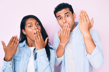 Güzel Latin bir çift, nişan yüzüğü takıyor ağızlarını eliyle kapatıyor, şok geçiriyor ve hata yapmaktan korkuyorlar. şaşırmış ifade 