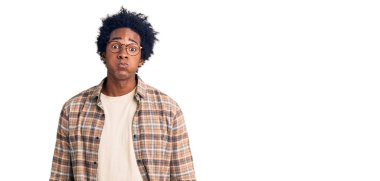 Afro saçlı, sıradan giyinmiş ve gözlüklü komik suratlı yakışıklı Afro-Amerikalı adam. Havayla şişmiş ağız, çılgın bir ifade.. 