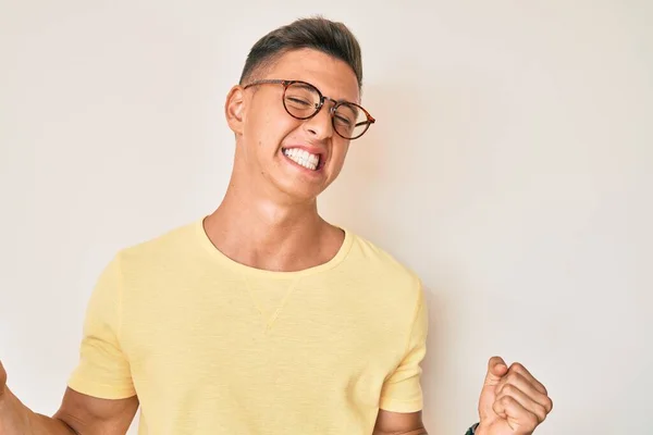 Mladý Hispánec Neformálním Oblečení Brýlích Velmi Šťastný Vzrušený Dělá Vítězný — Stock fotografie