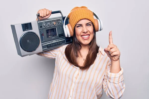 若い美しいブルネットの女性は ヴィンテージのBoomboxとヘッドフォンを使用して音楽に耳を傾けます笑顔でアイデアや質問を指差す指で幸せな顔 ナンバーワン — ストック写真