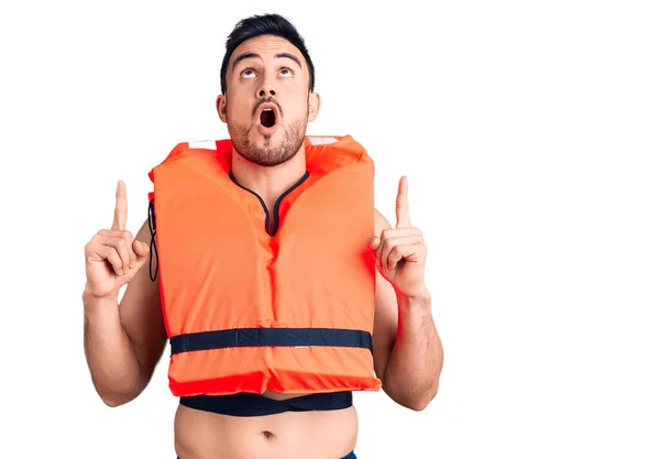 Young Handsome Man Wearing Lifejacket Amazed Surprised Looking Pointing Fingers — Stock Photo, Image