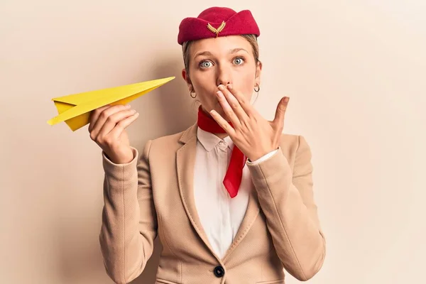 Fiatal Gyönyörű Szőke Lány Stewardess Egyenruhát Visel Papírrepülőt Tart Szájával — Stock Fotó