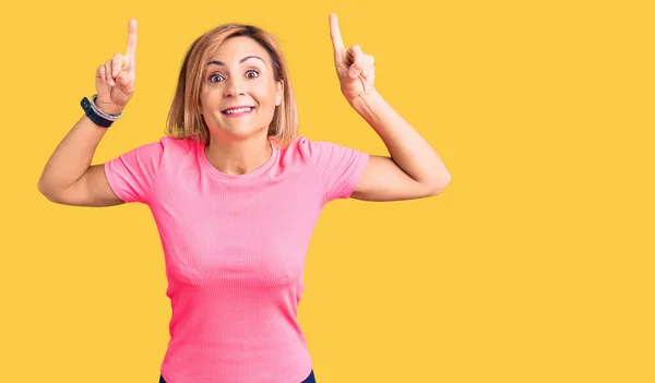 Mujer Rubia Joven Vistiendo Ropa Deportiva Sonriendo Asombrada Sorprendida Señalando — Foto de Stock