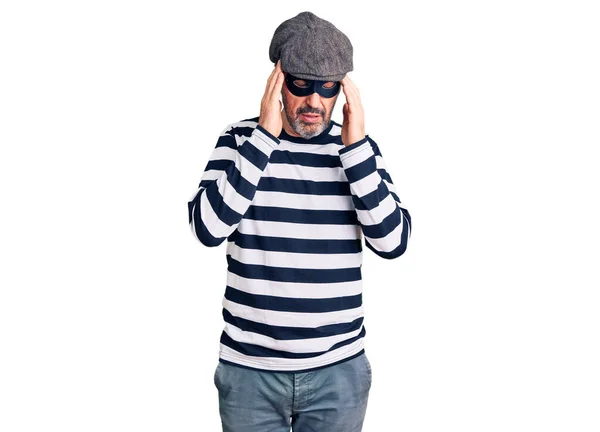 ストレスが原因で頭の痛みのために頭の上に手で強盗マスクを身に着けている中世のハンサムな男 片頭痛 — ストック写真