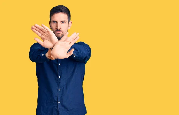 Jovem Homem Bonito Vestindo Casual Expressão Rejeição Camisa Cruzando Braços — Fotografia de Stock