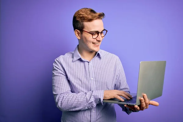 Mladý Pohledný Ryšavý Podnikatel Pracující Pomocí Notebooku Přes Fialové Pozadí — Stock fotografie